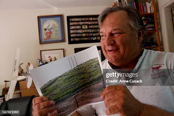 Sonny Klamerus a gardner by trade who dabbles in artistic endeavors of painting and wire sculpture poses for a portrait with a photo of the original...