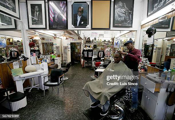 Jioe Randle gets a haircut from Leon Williams at Goof Fred Barber Shop in the South Los Angeles neighborhood known as Chesterfield Square. Per...