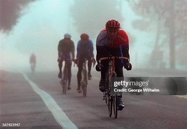 Group of bicyclists roll down a foggy Mulholland Highway near Las Virgenes Rd. Early this morning.