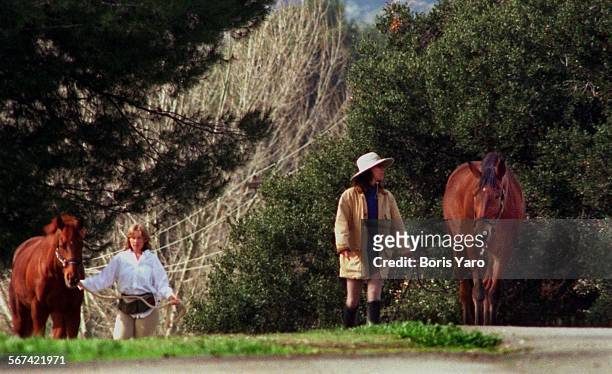 Two women walk horses along Stokes Canyon Road in Calabasas. ^^^/LA Times