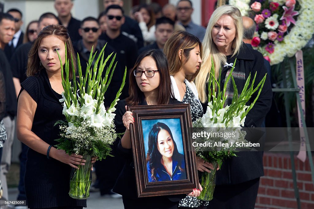 WESTMINSTER, CA-JAN. 28, 2014:   Mourners hold flowers and a portrait of Annie Hung ``Kim'' Pham as 