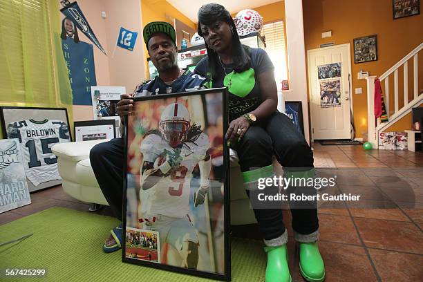 Kevin and Beverly Sherman, parents of Seattle Seahawks star cornerback Richard Sherman pose for a photo in their Compton home holding a poster of...