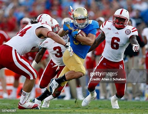 Full back Steven Manfro runs for yardage as Nebraska defenders Cameron Meredith, left, Daimion Stafford, middle, and Corey Cooper, right, try to stop...