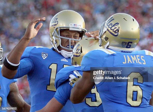 Quarterback Brett Hundley, left, celebrates Steven Manfro's second quarter touchdown with Jordon James, right, past Nebraska's defense at the Rose...