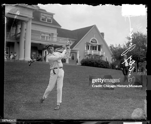 Golfer Bobby Jones swinging a golf club, standing on a lawn of the Midlothian Country Club, Midlothian, Illinois, 1917.