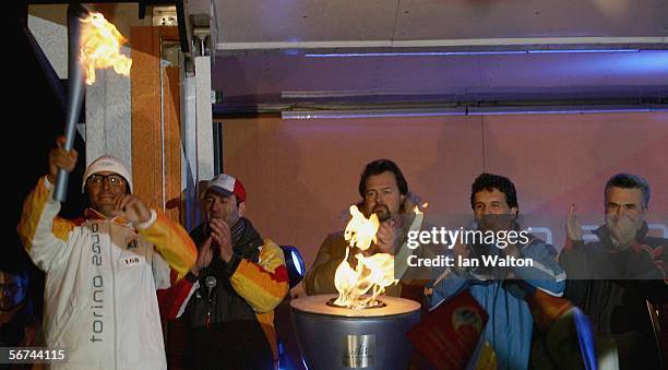 The Torino 2006 Olympic Torch Relay reaches the town of Sestriere, as torch bearer Martin Gianfranco holds the flame aloft in Fraiteve Piazza...