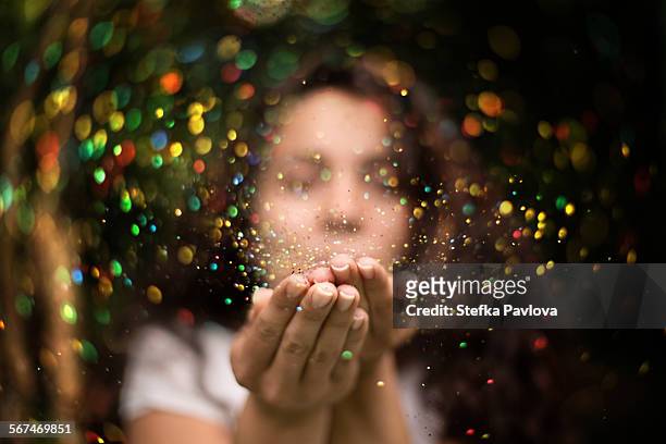 young woman blows glitter into the air - brocade stock pictures, royalty-free photos & images