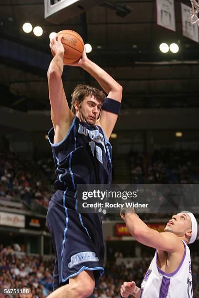 Mehmet Okur of the Utah Jazz grabs the rebounf over Mike Bibby of the Sacramento Kings on February 5, 2006 at the ARCO Arena in Sacramento,...