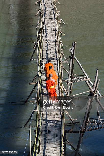 monks crossing nam khan river - cyril eberle stockfoto's en -beelden