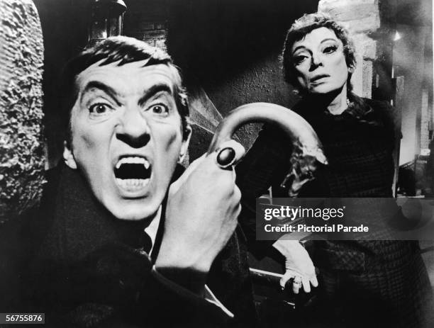 Publicity portrait of Canadian actor Jonathon Frid, a metal-tipped cane in his hand as he bares his fangs as the vampire character Barnabas Collins,...