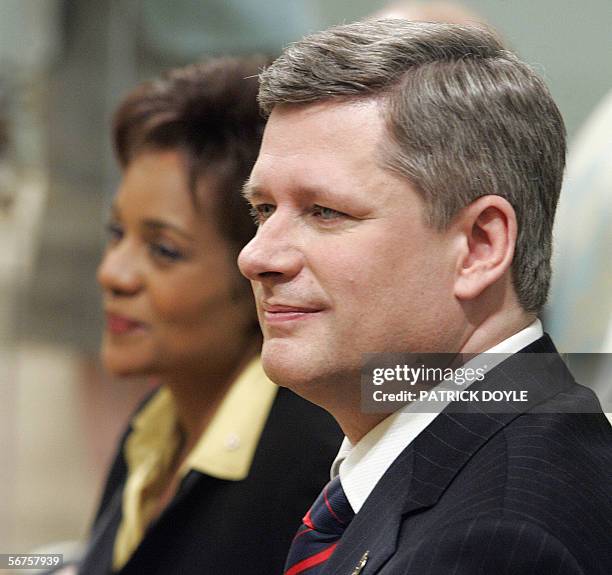 Stephen Harper , the new Prime Minister of Canada, watches his cabinet ministers being sworn in with Governor General Michaelle Jean during a...