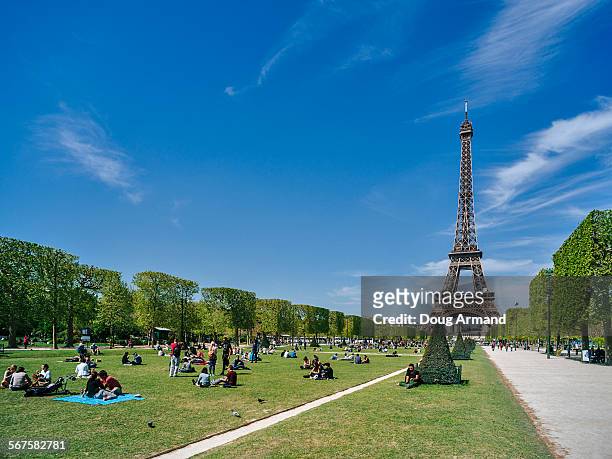 the eiffel tower set against a blue sky - champs de mars stock pictures, royalty-free photos & images