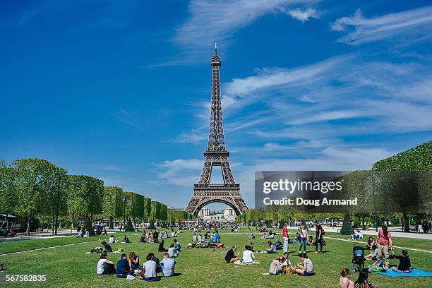 the eiffel tower set against a blue sky - champ de mars stock pictures, royalty-free photos & images