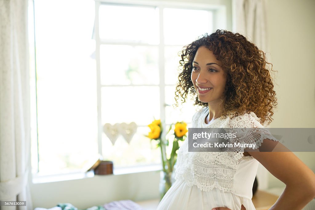 A mixed race pregnant lady tries on new clothes