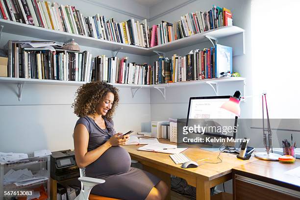 pregnant lady works from her home office - mobile first fotografías e imágenes de stock