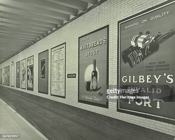 Advertisements for beer and port, Holborn Underground Tram Station, London, 1931. Advertising posters on the south-bound platform at Holborn...