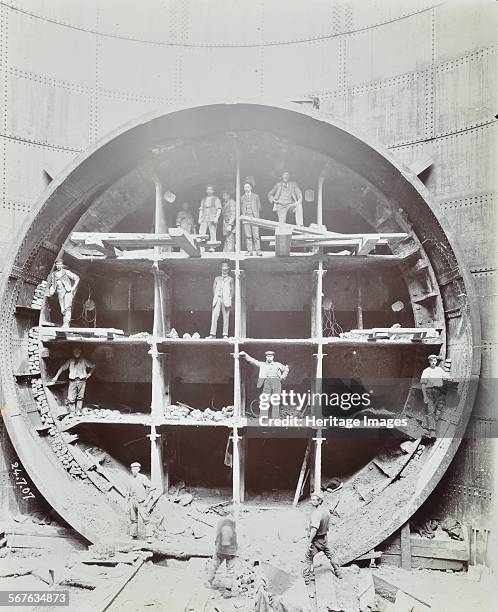 Men standing in the shield used to cut Rotherhithe Tunnel, Bermondsey, London, July 1907. Front view of the cutting edge of the shield where it...