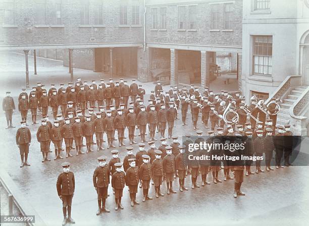 Boys on parade at the Boys Home Industrial School, Regent's Park Road, London, 1900. Boys in uniform stand in line; a brass band plays on the right.