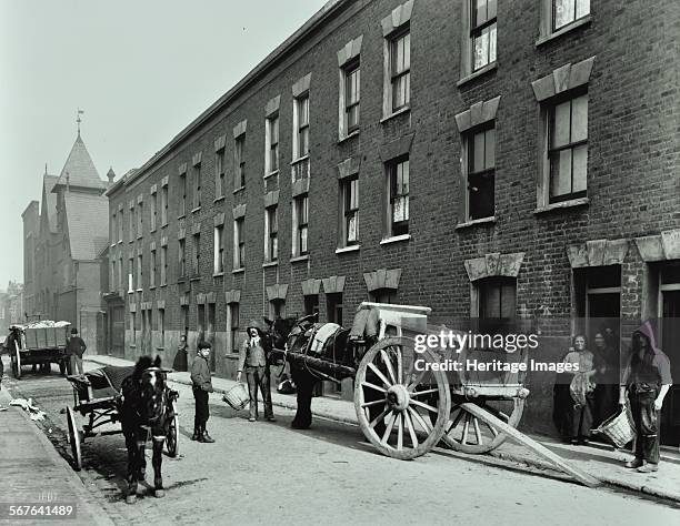 Dustmen and dust cart in Beckett Street, Camberwell, London, 1903. A horse waits with a cart while men with baskets collect refuse from three-storey...