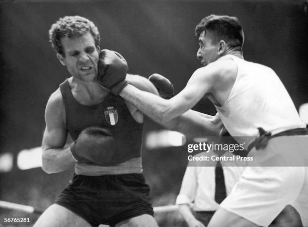 Giacomo de Segni of Britain takes a left-handed punch from Donald Scott of Britain in the Olympic Light-Heavyweight Boxing quarter-finals at Wembley,...