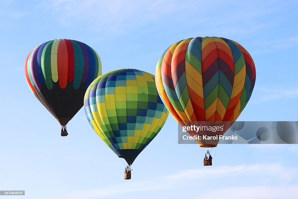 Three colorful hot air balloons in the sky