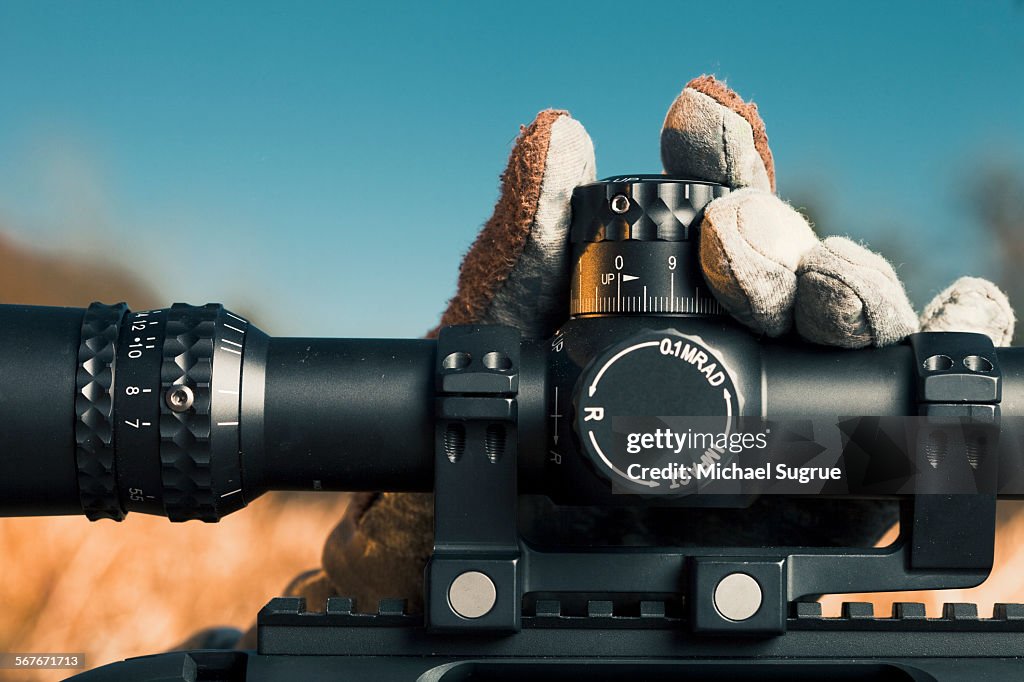 Man adjusts gauge on rifle.