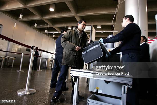 Department of Homeland Security official assists commuters passing through weapon-detection equipment at Exchange Place station on the first day of...