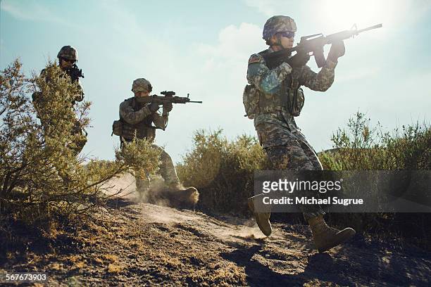 army soldiers advancing in combat. - armée américaine photos et images de collection