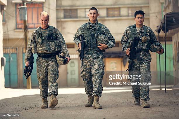 army troops walk down a street in combat. - personal militar fotografías e imágenes de stock