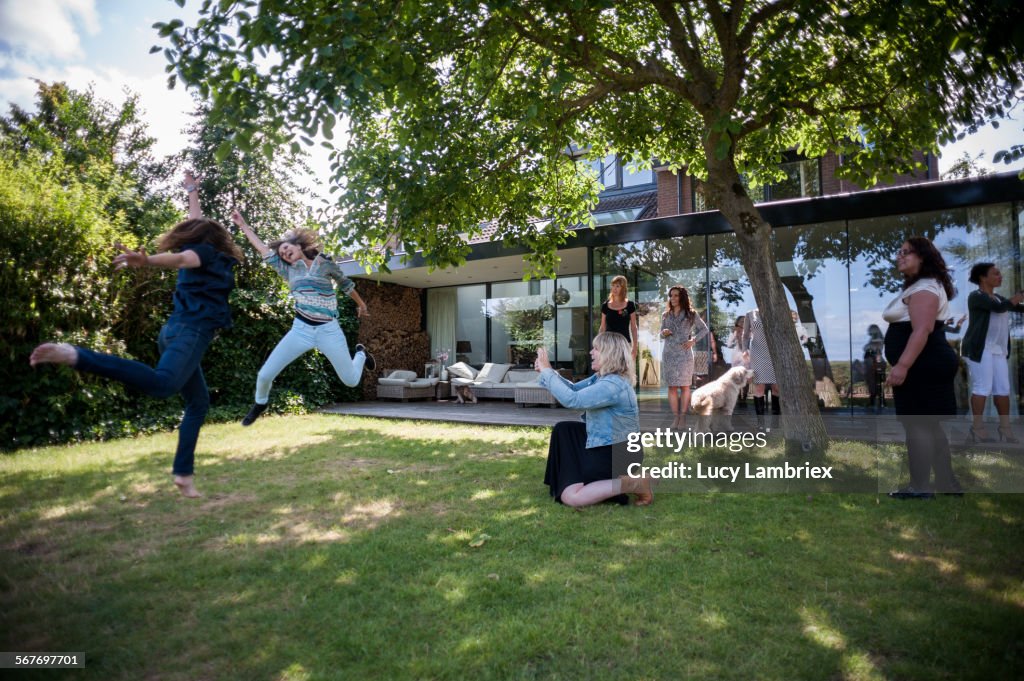 Woman taking picture of two jumping women