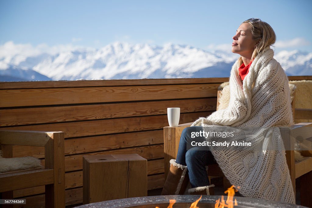 Woman day dreaming at the terrace of a hotel, Crans-Montana, Swiss Alps, Switzerland