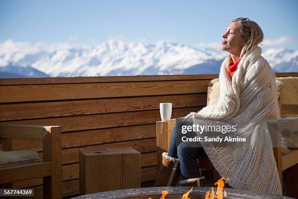 woman day dreaming at the terrace of a hotel, crans-montana, swiss alps, switzerland - hot blonde woman stock-fotos und bilder