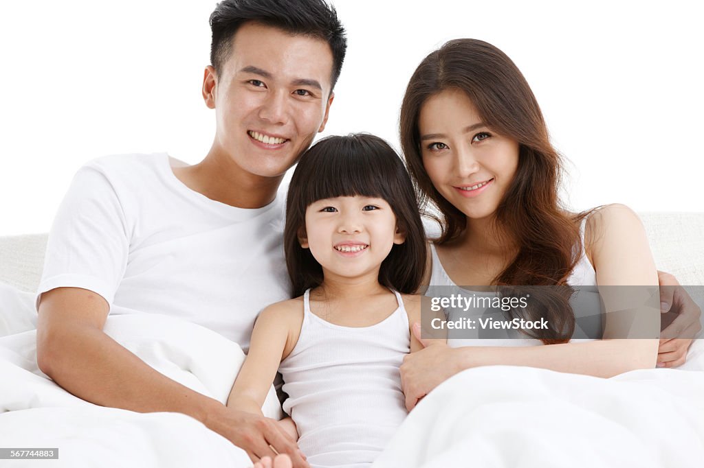 The happiness of a family of three in the bed of the bedroom