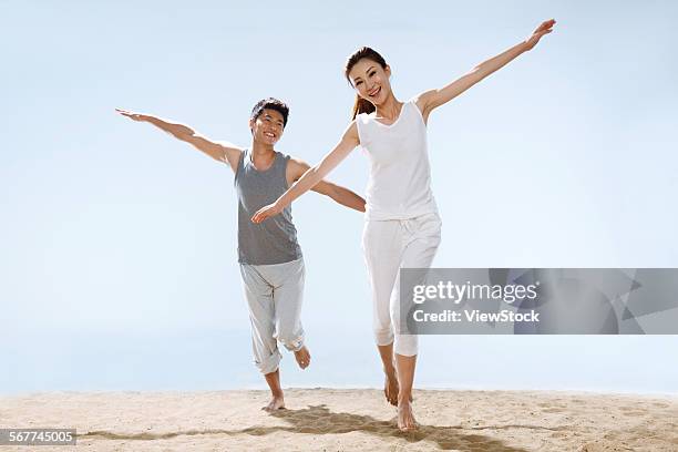 romantic couples running on the beach - 飛行機のまね ストックフォトと画像