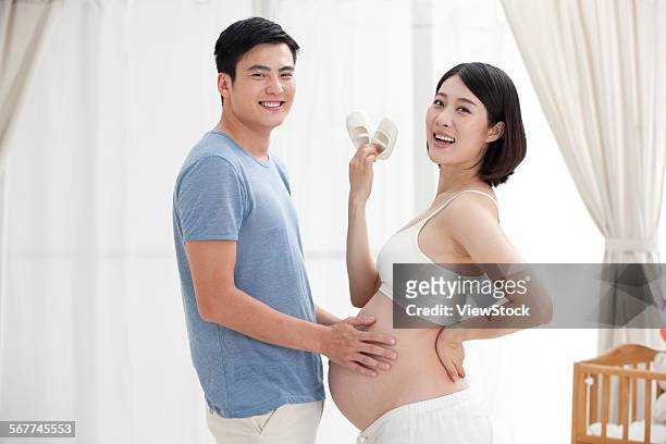 the happiness of the young couple in the living room - chinese baby shoe stock pictures, royalty-free photos & images