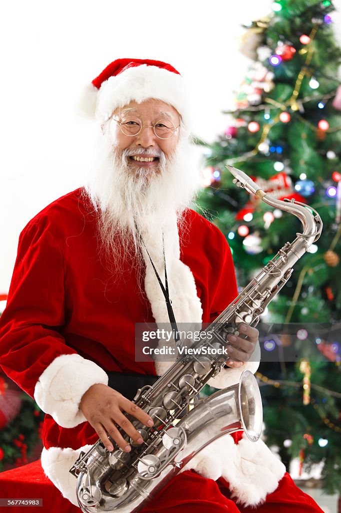 A old man wearing a Christmas dress holds the saxophone