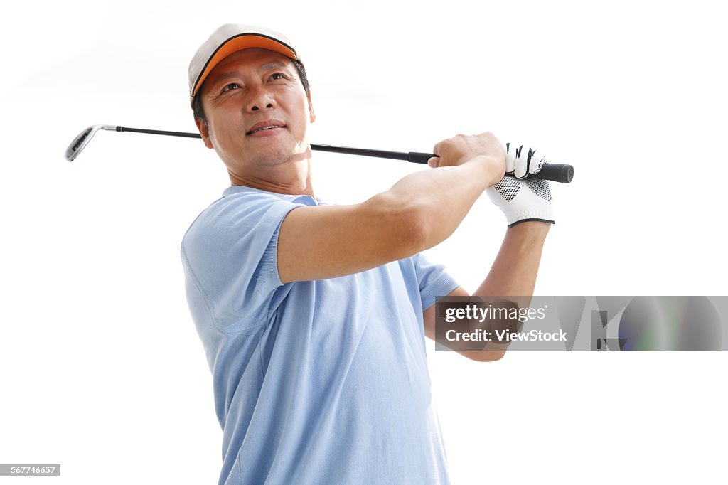 A middle-aged man is playing golf