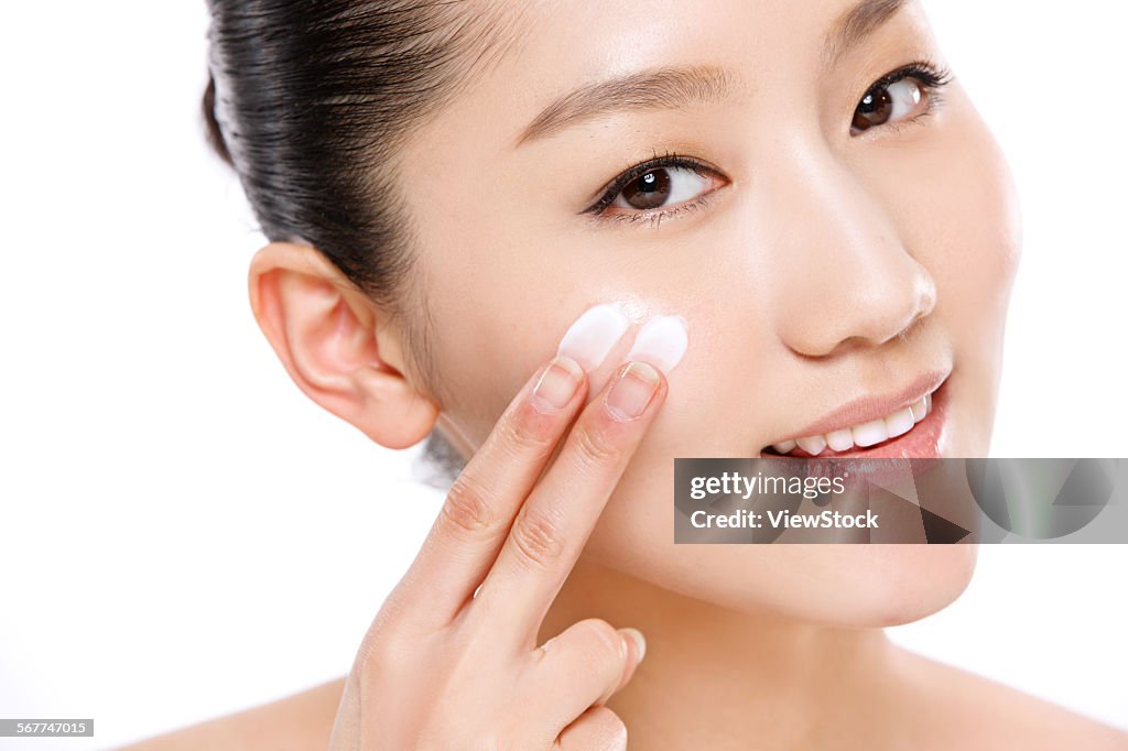 Beautiful Asian woman in painted skin care products