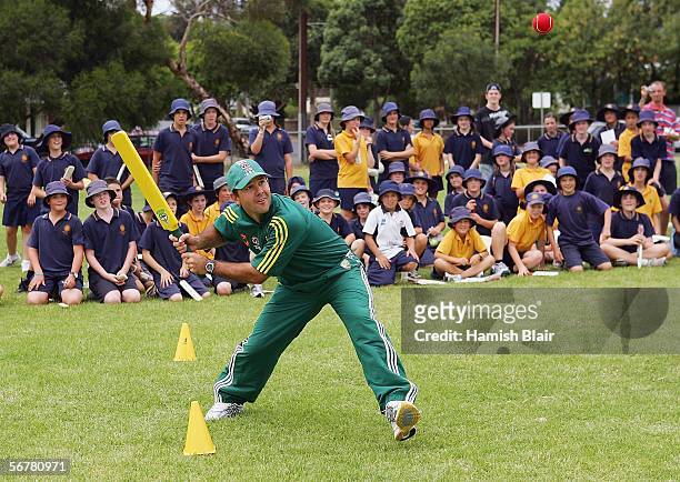 Ricky Ponting hits a ball with students looking on during a "Back to School" program, where elite Australian cricketers visit schools to share their...