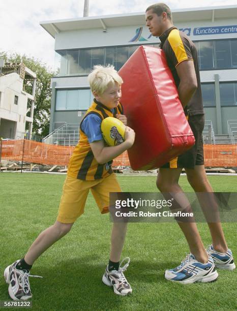 Lance Franklin of the Hawks teaches a young boy how to bump on the tackle bag during the Super Clinic which is part of the Hawthorn AFL Community...