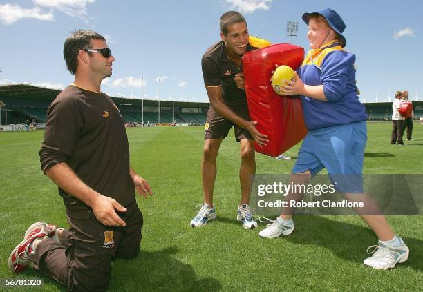 Brent Guerra and Lance Franklin of the Hawks teach a young girl how to bump on the tackle bag during the Super Clinic which is part of the Hawthorn...