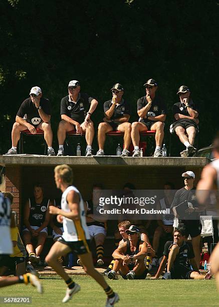 The Richmond coaching staff sit on top of an interchange bench to view an intra-club practice match held during the Richmond AFL Community Camp at...