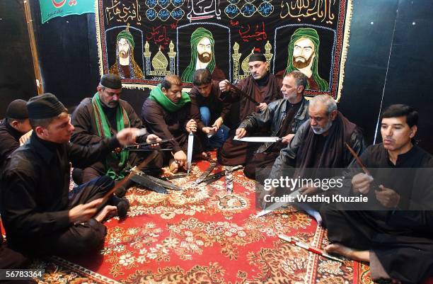 Iraqi Shiite men clean their swords as they prepare to flagellate themselves in honour of Imam Hussein's death anniversary on February 8, 2006 in the...