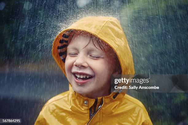 happy smiling little boy in the rain - レインコート ストックフォトと画像
