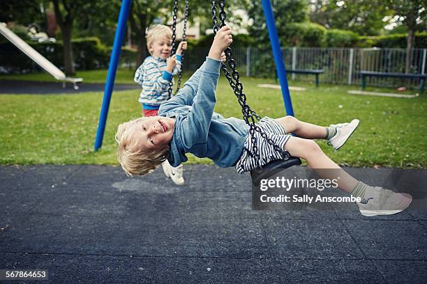children playing on the swings - schaukel stock-fotos und bilder