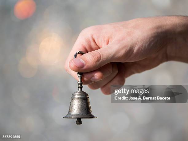 hand holding a small bell - handbell stock pictures, royalty-free photos & images