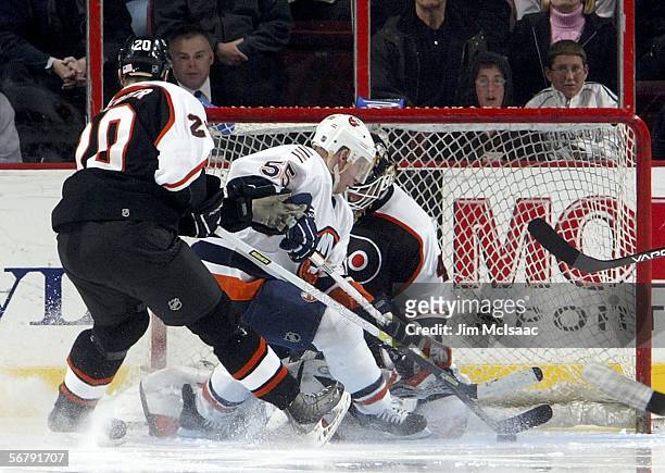 Robert Esche and R.J. Umberger of the Philadelphia Flyers stop Jason Blake of the New York Islanders from scoring on February 8, 2006 at the Wachovia...