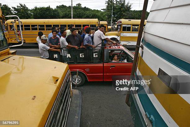 Trabajadores a bordo de una camioneta pasan frente a autobuses de transporte urbano detenidos a causa de un paro, el 09 de febrero de 2006, en...