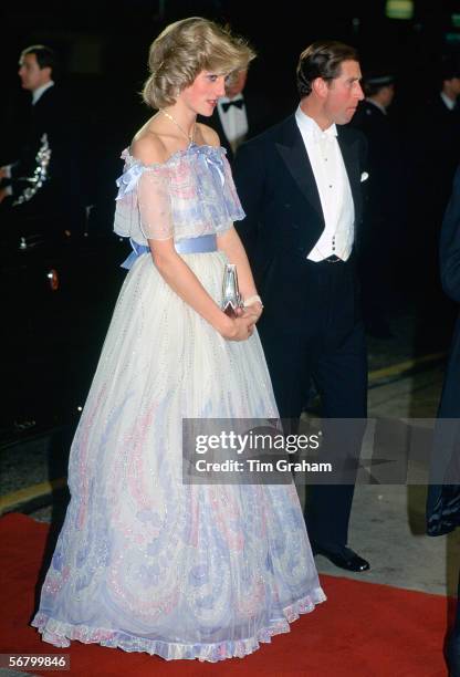 The Prince and Princess of Wales attending a Royal Variety Performance. Diana is wearing a chiffon evening dress designed by fashion designer...