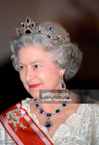 Queen Elizabeth II attending a banquet in Prague wearing a sapphire and diamond tiara which she had made to match the cluster necklace and earrings...
